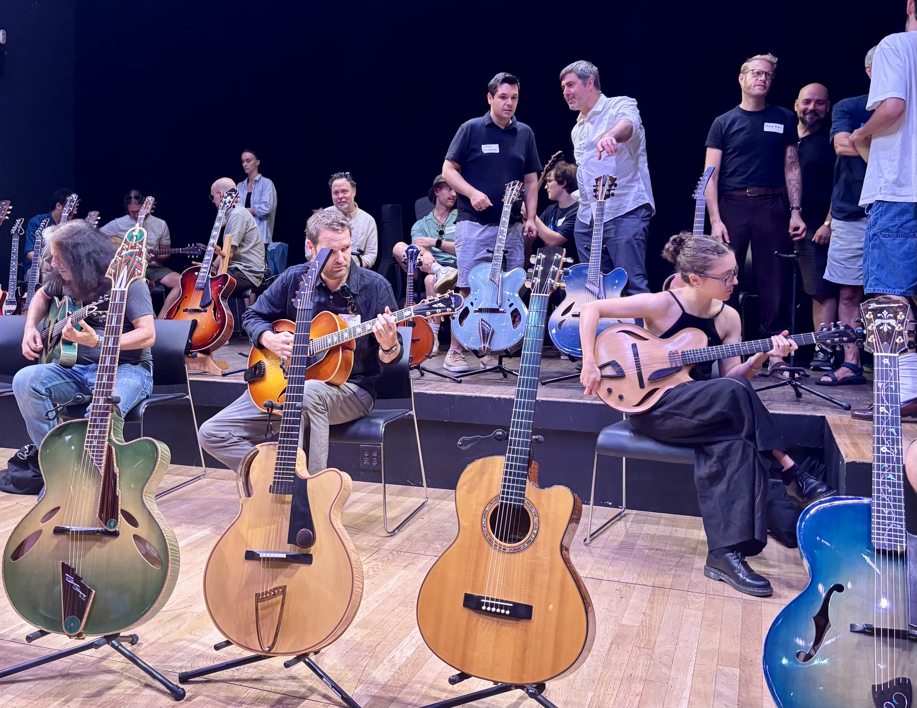 Brooklyn Guitar Feast III attendees trying guitars across the Roulette stage.