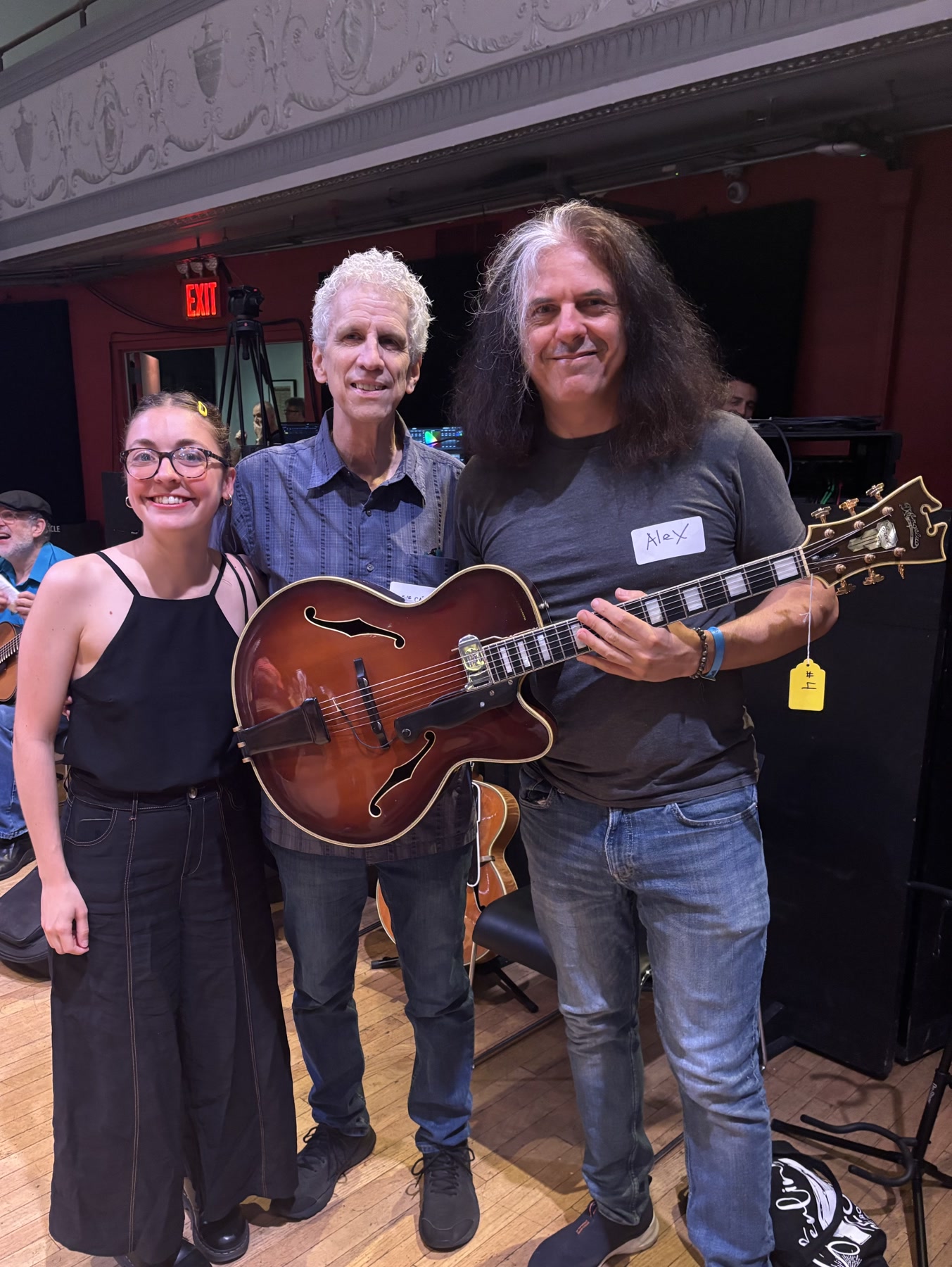 Three Brooklyn Guitar Feast III attendees posing together with an archtop guitar.